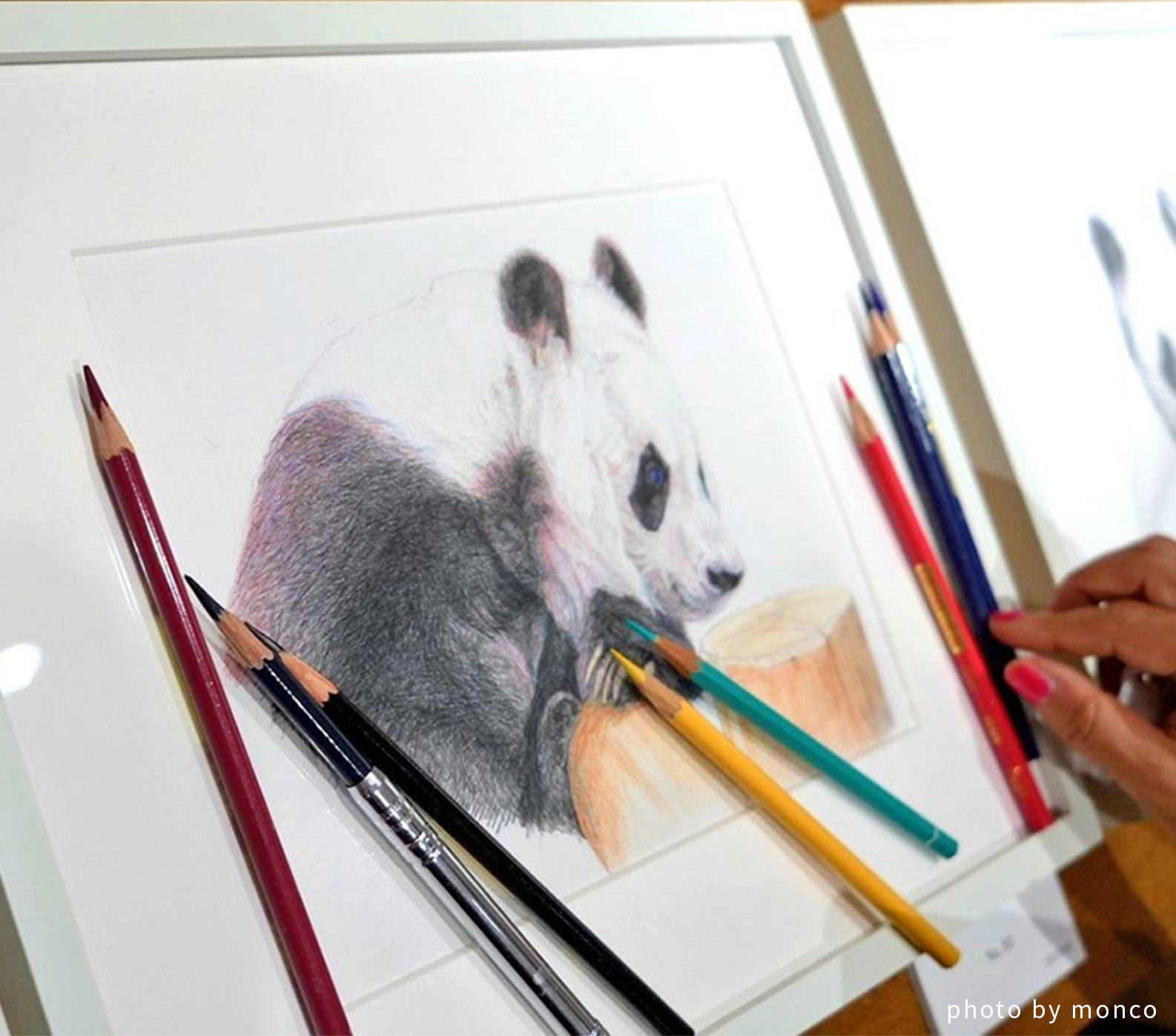 パンダの絵画と色鉛筆。作者の手元も写っている